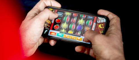 Jemand spielt Glücksspiel auf dem Smartphone (nah)