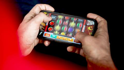 Jemand spielt Glücksspiel auf dem Smartphone (nah)