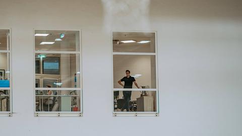 Skyliner-Geschäftsführer Yannick Binas durch eine Scheibe in seinem Büro fotografiert.