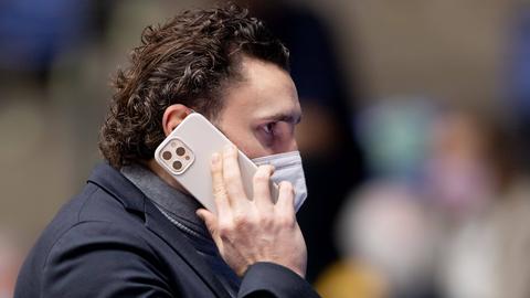 Marco Völler telefoniert mit Maske am Handy