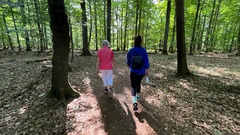 Zwei Personen gehen durch den Wald