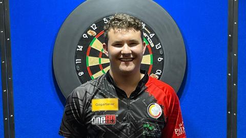 Fabian Schmutzler vor einer Dartscheibe
