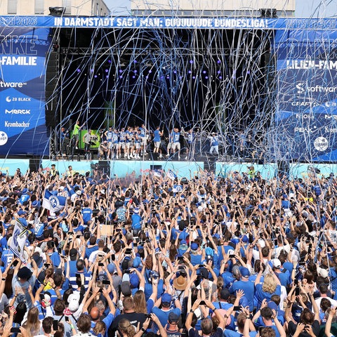 Tausende Fans feiern ausgelassen vor der großen Bühne ihre Mannschaft