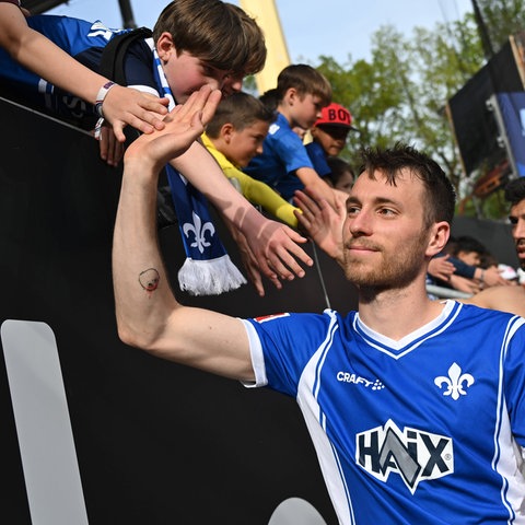 Matthias Bader vom SV Darmstadt klatscht mit den Fans ab