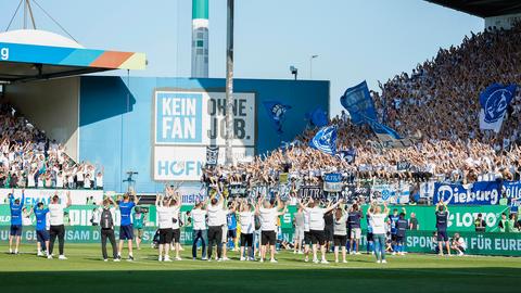 Die Spieler des SV Darmstadts feiern vor ihren Fans mit den Händen in der Luft.