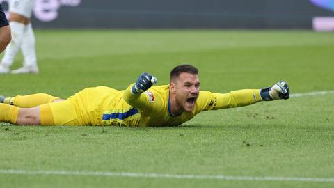 Marcel Schuhen liegt mit ausgestreckten Armen jubelnd auf dem Platz.