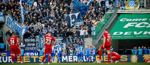 Die Darmstädter Fans jubeln mit ihren Spielern in Köln.