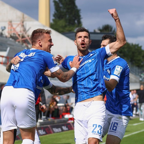 Klaus Gjasula (2.v.r.) feiert mit seinen Kollegen.