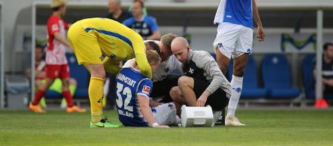 Fabian Holland wird gegen Freiburg auf dem Spielfeld behandelt.