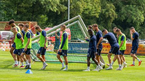 Die Mannschaft des SV Darmstadt 98 trägt ein Tor über den Trainingsplatz. 