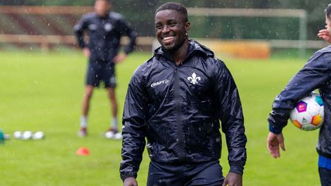 SVD-Spieler Braydon Manu steht im Regen auf einem Trainingsplatz und lacht