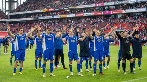Die Darmstädter Fußballer jubeln in Köln vor ihren Fans.