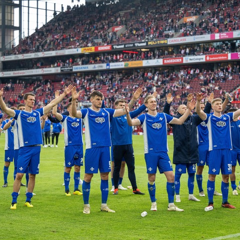 Die Darmstädter Fußballer jubeln in Köln vor ihren Fans.
