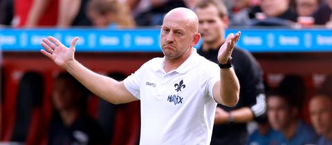 Torsten Lieberknecht mit weißem Shirt und fragendem Blick.
