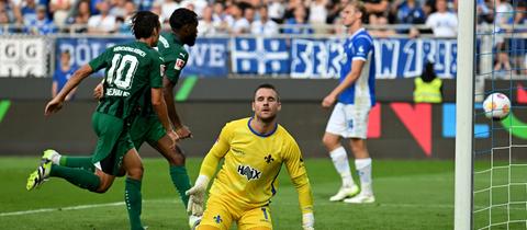 Marcel Schuhen auf dem Boden, hinter ihm jubelt Mönchengladbach.