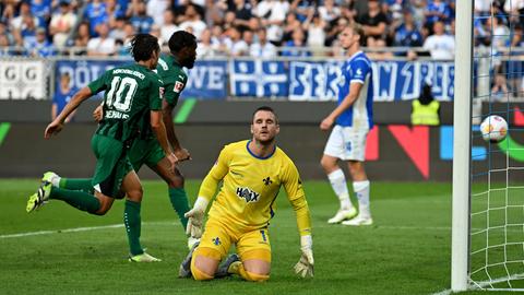 Marcel Schuhen auf dem Boden, hinter ihm jubelt Mönchengladbach.