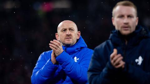 Darmstadt Trainer Torsten Lieberknecht mit dicker blauer Jacke. Daneben etwas unscharf: Kapitän Fabian Holland.