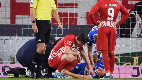 Christoph Zimmermann liegt verletzt am Boden. Die umstehenden Spieler schauen sorgenvoll.