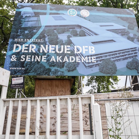 Ein Schild auf einer Mauer mit der Aufschrift "Der neue DFB & seine Akademie".