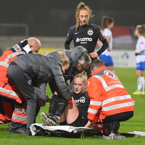 Camilla Küver von Eintracht Frankfurt wird auf dem Platz behandelt.