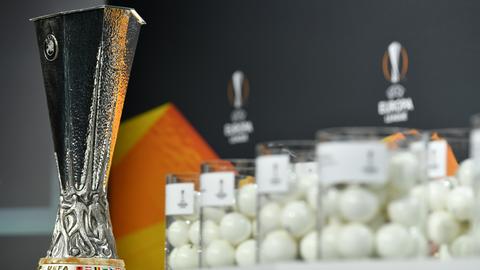 Der Pokal der Europa League steht neben den Kugeln der Auslosung