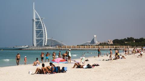 Blick auf einen Strand und den Burj Al Arab in Dubai.