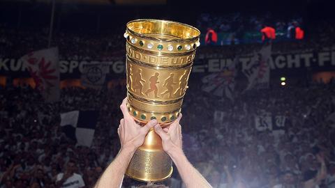 Der goldene DFB-Pokal vor der Kurve der Eintracht-Fans.