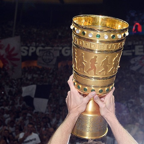 Der goldene DFB-Pokal vor der Kurve der Eintracht-Fans.