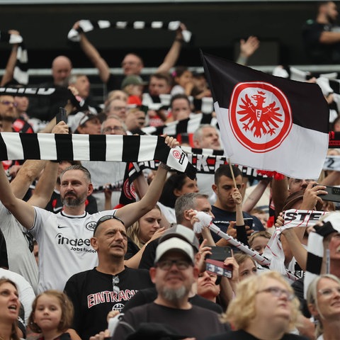 Eintracht-Fans halten bei der Saisoneröffnung gegen Nottingham Forest schwarz-weiße Schals und Fahnen hoch.