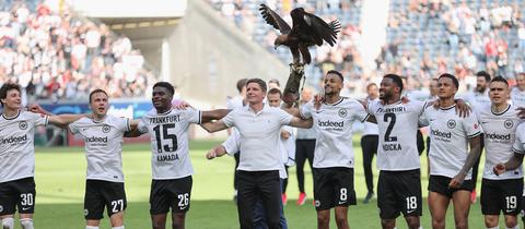 Die Spieler von Eintracht Frankfurt und Trainer Glasner stehen Arm in Arm vor der Kurve.