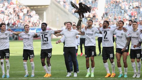 Die Spieler von Eintracht Frankfurt und Trainer Glasner stehen Arm in Arm vor der Kurve.