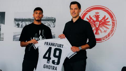Frankfurts Sportdirektor Timmo Hardung und Harpreet Ghotra halten dessen Eintracht-Trikot.