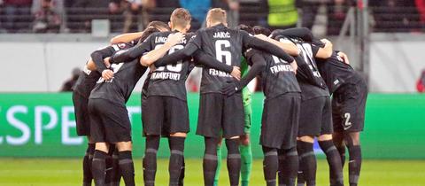 Die Spieler von Eintracht Frankfurt stehen im Kreis beisammen und besprechen etwas