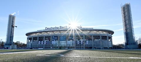 Das Stadion von Eintracht Frankfurt in der Außenansicht gegen das Licht fotografiert, so dass es unter funkelnder Sonne fast wie ein Scherenschnitt erscheint.