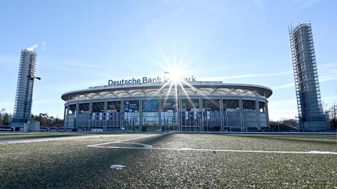 Das Stadion von Eintracht Frankfurt in der Außenansicht gegen das Licht fotografiert, so dass es unter funkelnder Sonne fast wie ein Scherenschnitt erscheint.