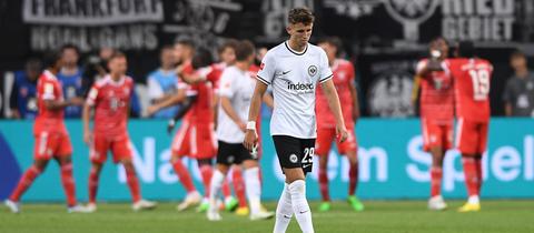 Jesper Lindström schaut geknickt. Im Hintergrund jubeln die Bayern.