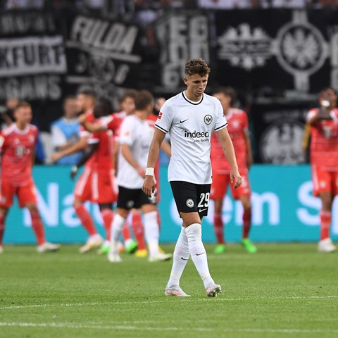 Jesper Lindström schaut geknickt. Im Hintergrund jubeln die Bayern.