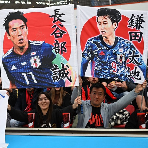 Japanische Fans in Leverkusen haben Plakate von Makoto Hasebe und Daichi Kamada dabei.