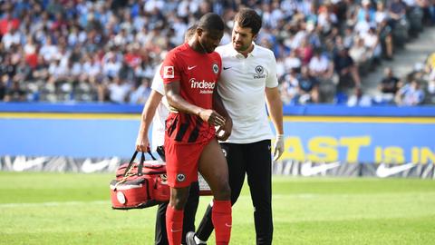 Eintracht-Verteidiger Almamy Touré wird verletzt vom Feld begleitet.