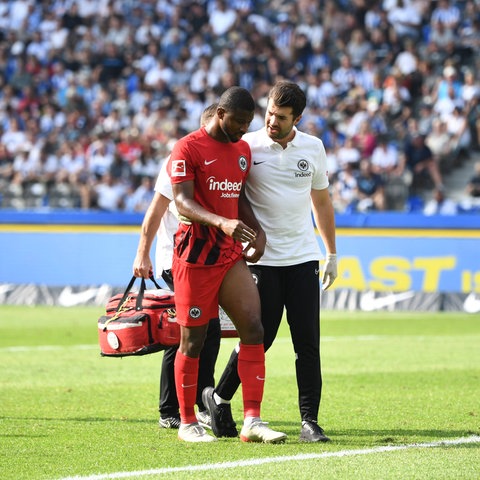 Eintracht-Verteidiger Almamy Touré wird verletzt vom Feld begleitet.