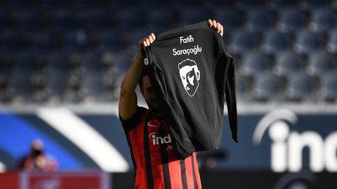 Amin Younes hält ein T-Shirt an Gedenken an die Opfer von Hanau hoch