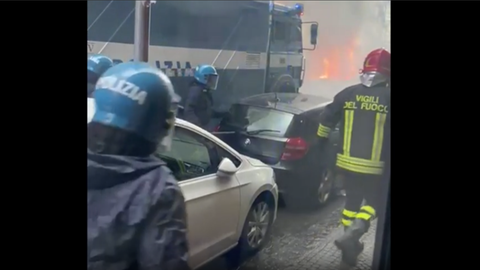 Feuerwer und Polizei in Neapel. Im Hintergrund brennen Autos.