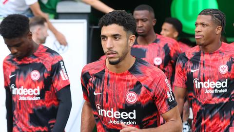 Omar Marmoush im Vordergrund. Die Eintracht-Spieler kommen zum Warmlaufen ins Wolfsburger Stadion.