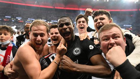 Evan N'Dicka feiert mit Fans auf dem Rasen.