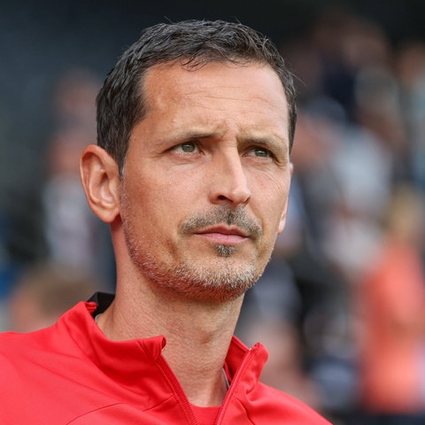 Frankfurts Trainer Dino Toppmöller mit ernstem Blick und roter Jacke.