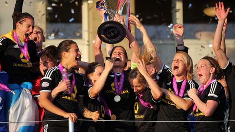 Die Fußballerinnen des FFC halten den Champions-League-Pokal hoch.