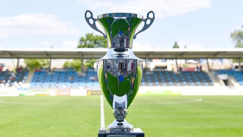 Der große silberne Pokal im Vordergrund. Im Hintergrund ist das Stadion am Bornheimer Hang zu sehen.