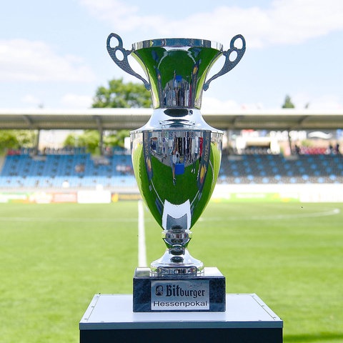 Der große silberne Pokal im Vordergrund. Im Hintergrund ist das Stadion am Bornheimer Hang zu sehen.