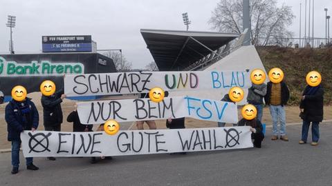 Fans des FSV Frankfurt halten das umstrittene Banner vor dem Stadion in die Höhe