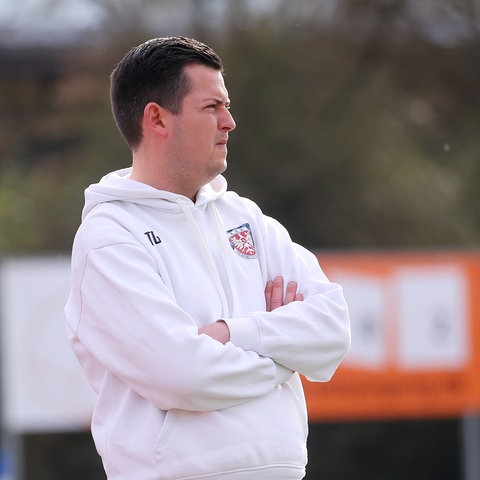 FSV-Trainer Tim Görner mit verschränkten Armen und Blick auf das Spielfeld.